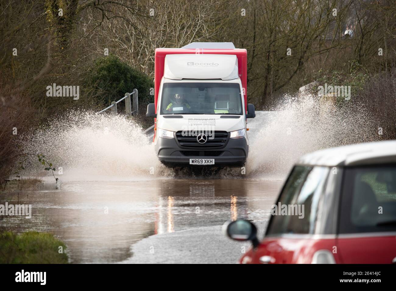 Ein Ocado-Lieferwagen fährt durch eine überflutete Straße an der Grenze zu Leicestershire. Verkehr Versuchen Sie, die überflutete Ratcliffe Road auf der Warwickshire, Leicestershire Grenze zu navigieren. Die Überschwemmungen durch Sturm Christoph führten zu schweren Überschwemmungen in der Region. Stockfoto