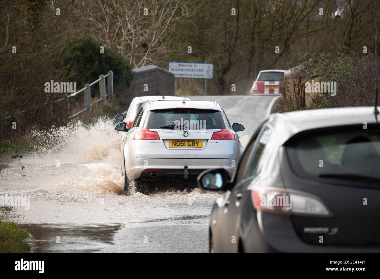 Verkehr Versuchen Sie, die überflutete Ratcliffe Road auf der Warwickshire, Leicestershire Grenze zu navigieren. Die Überschwemmungen durch Sturm Christoph führten zu schweren Überschwemmungen in der Region. Stockfoto
