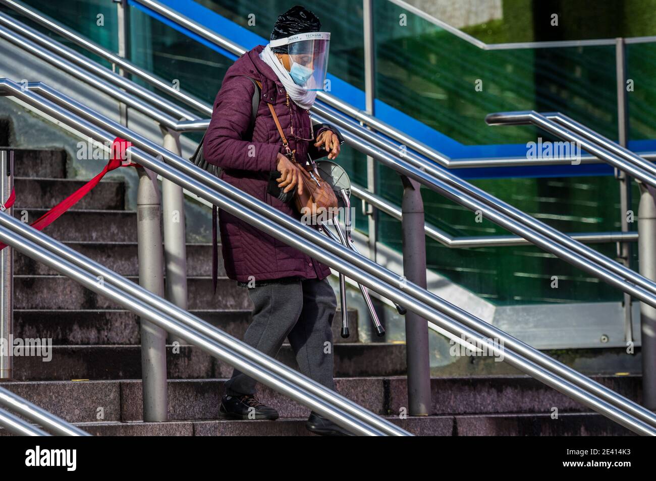 London, Großbritannien. Januar 2021. Eine Frau mit Visier und Maske kommt von der U-Bahnstation die Stufen hinunter. Aber es ist ruhig, nur wenige Leute kommen an und alle, die Termine haben müssen. Das Covid 19 Massenimpfzentrum in der Nähe des Wembley Stadions. Es ist die dritte Woche der nationalen Lockdown 3 und die Regierung Anweisung ist für alle zu Hause zu bleiben, um den Druck auf die NHS zu retten. Kredit: Guy Bell/Alamy Live Nachrichten Stockfoto