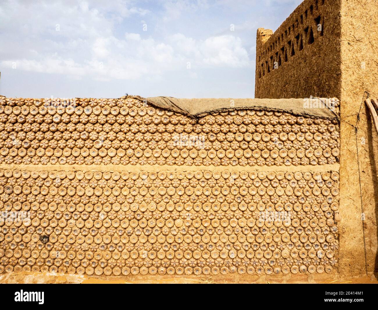 Wand aus recycelten Plastikflaschen in einem Haus in der Sahara in Marokko gebaut. Stockfoto