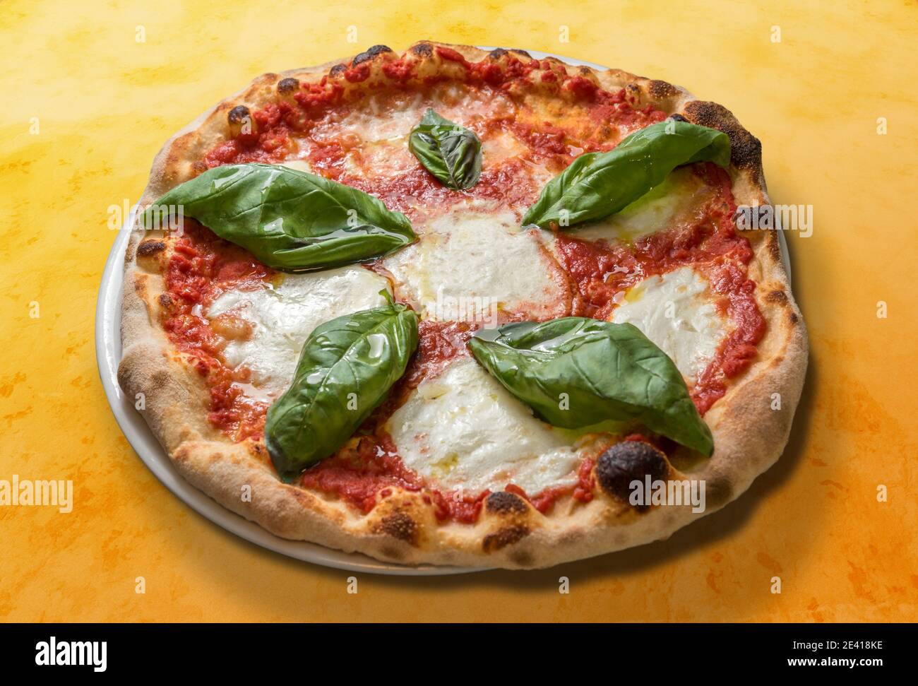 margherita Pizza mit Tomatenbasilsauce und Mozzarella Käse auf Orange gepunkteter Hintergrund Stockfoto