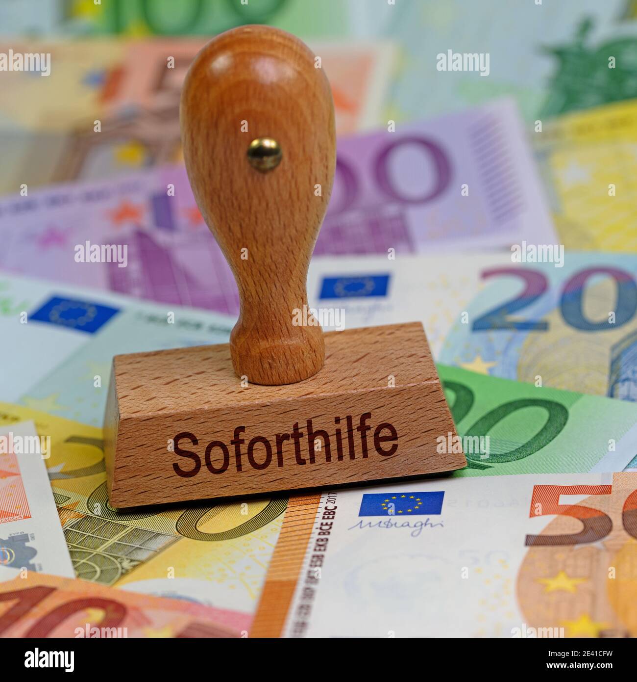 Stempel mit dem Wort 'Soforthilfe' auf Banknoten, Übersetzung 'Nothilfe' Stockfoto