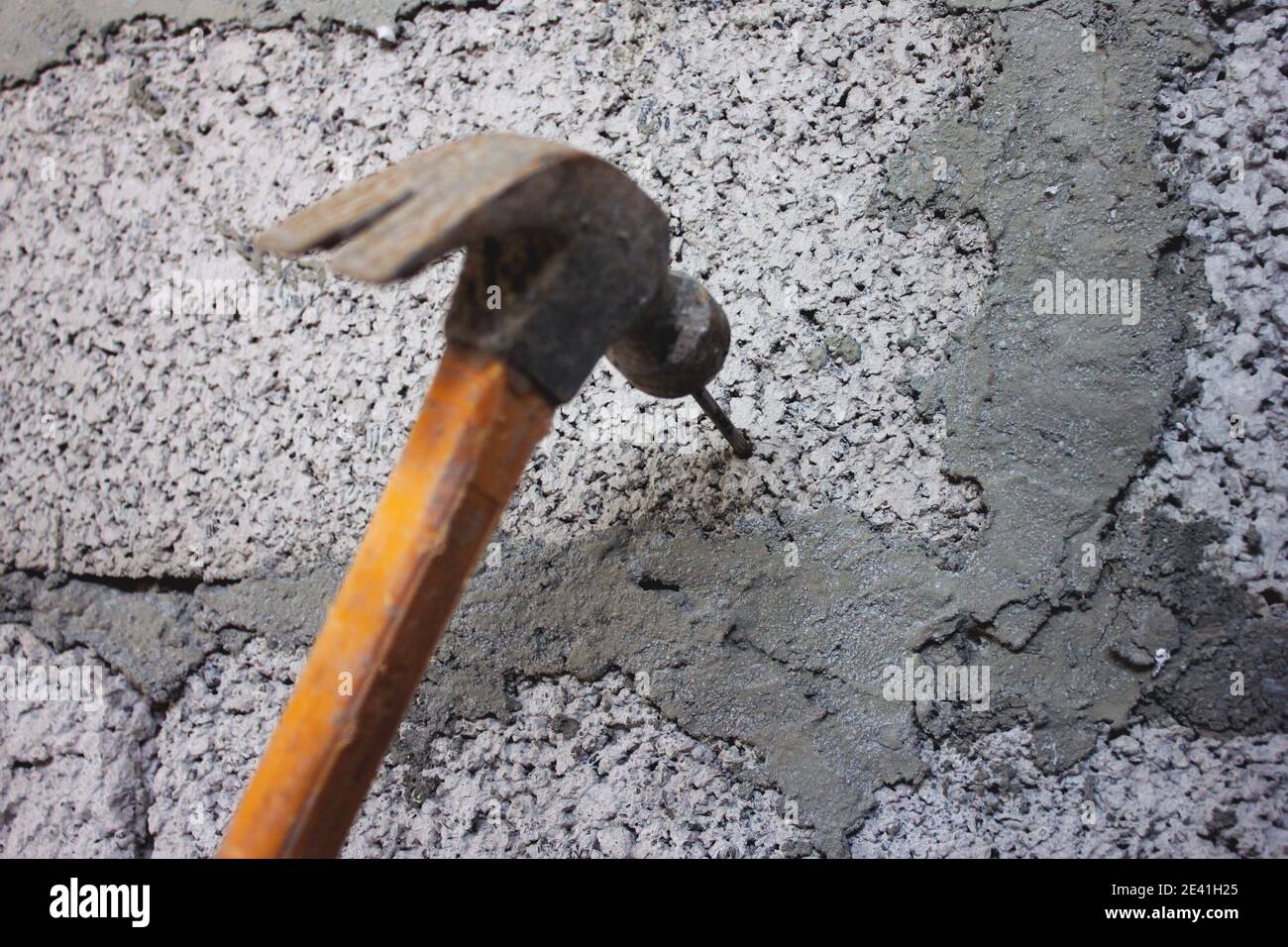 Die Hand des Menschen setzt einen Nagel. Stockfoto