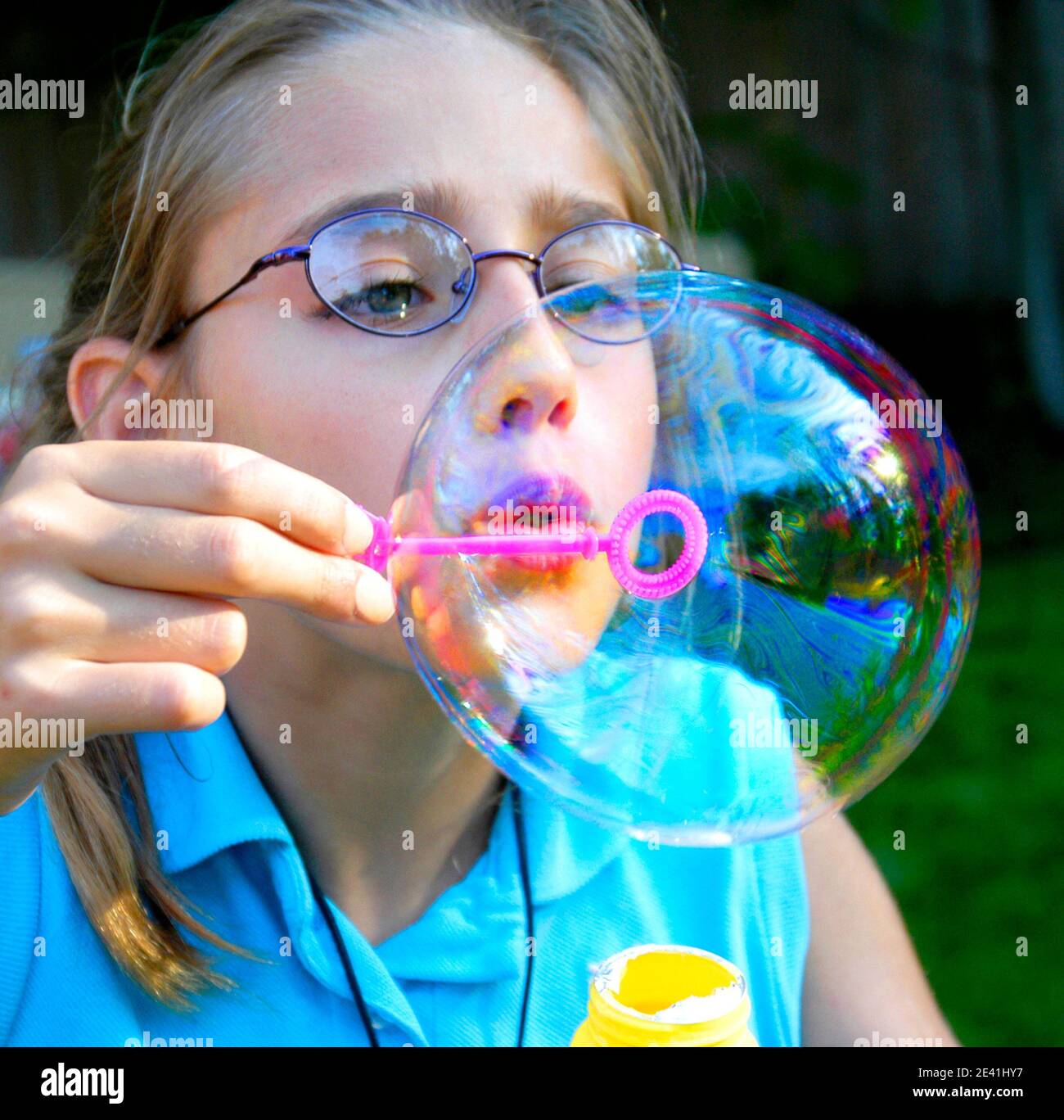 Mädchen weht große Seifenblasen aus einer Blase Zauberstab Stockfoto