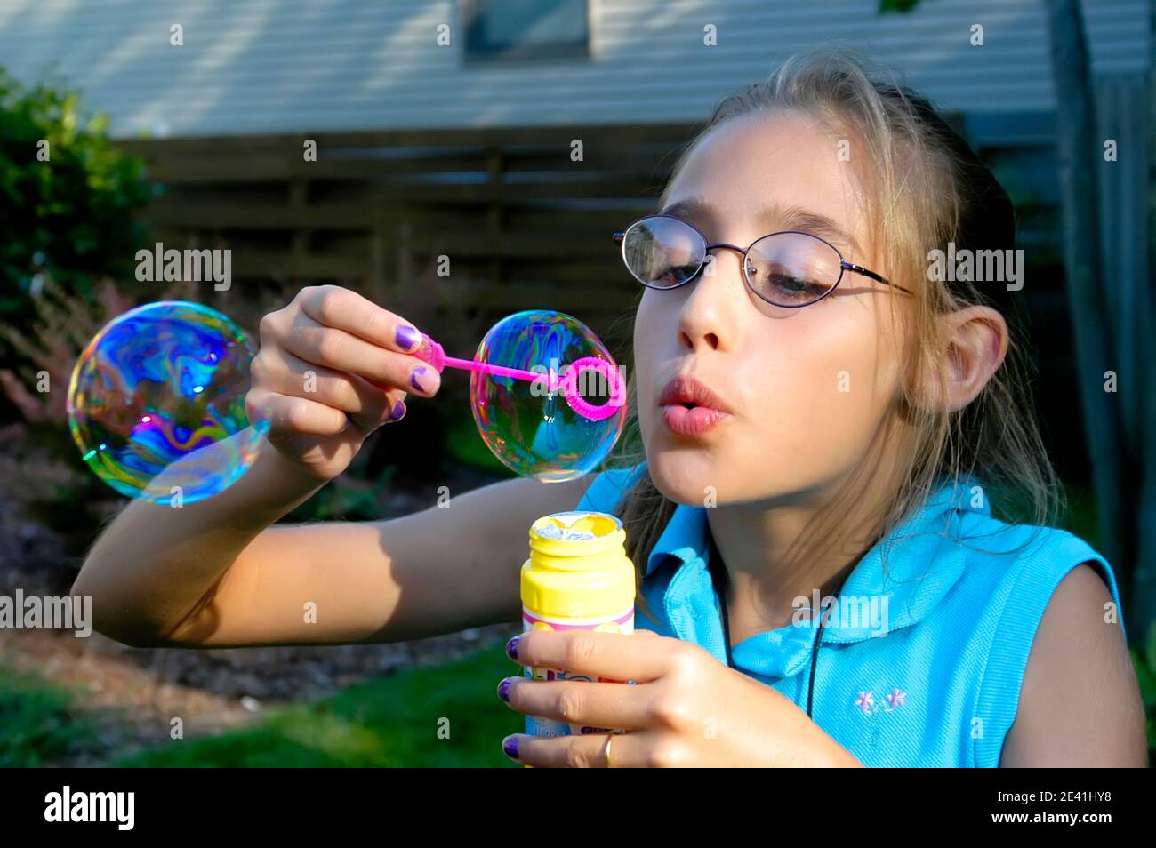 Mädchen weht große Seifenblasen aus einer Blase Zauberstab Stockfoto