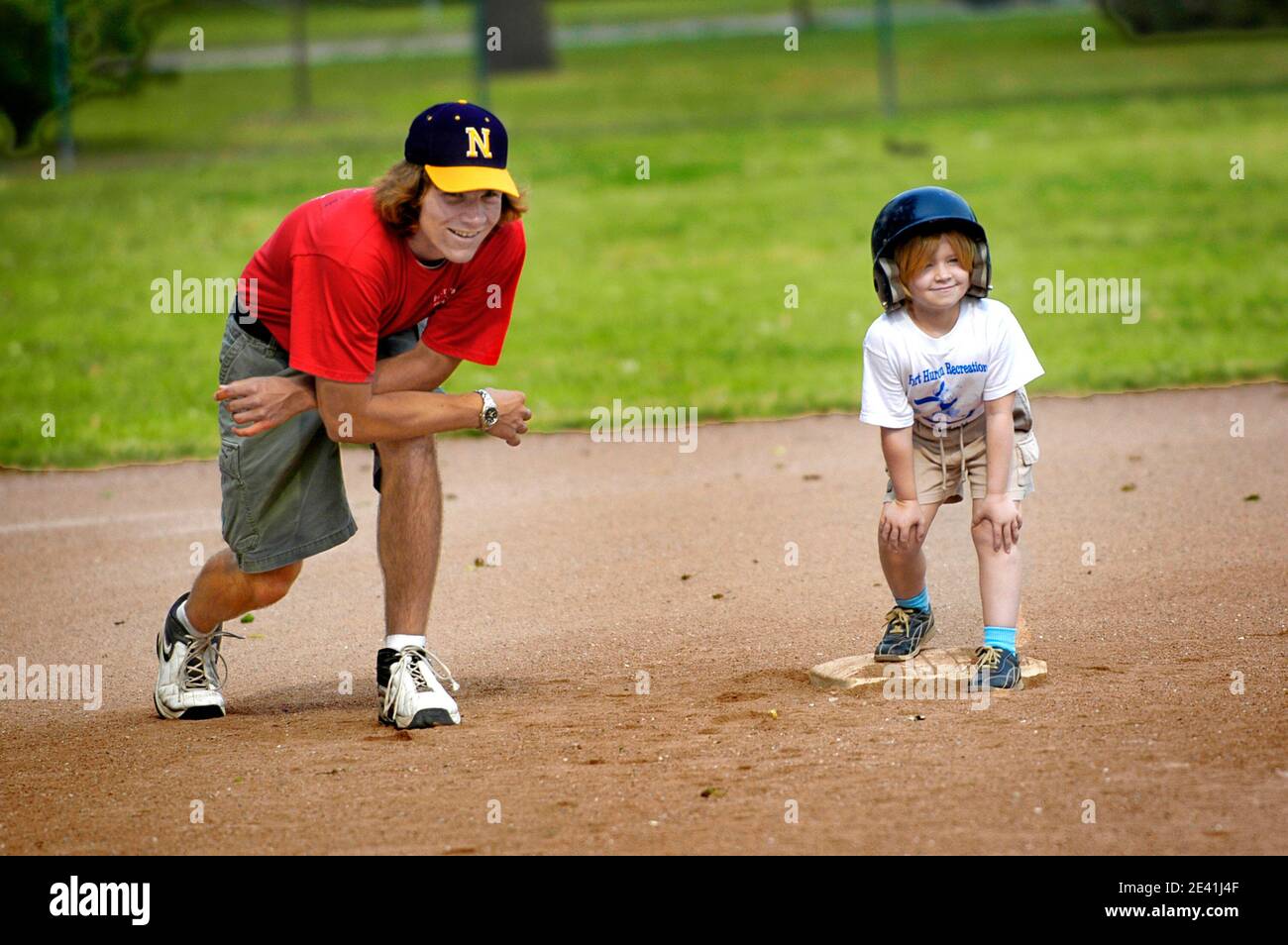 7 Jahre altes Mädchen im Gespräch mit ihrem Trainer Baseball-Unterricht Durch die Einführung in T Ball Little League Stockfoto