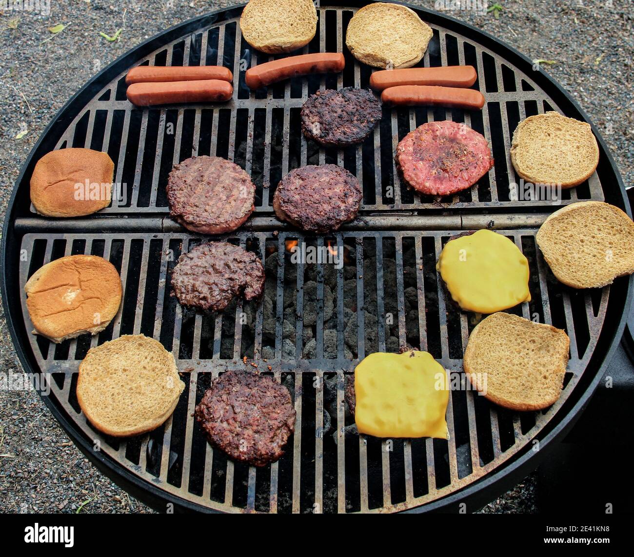 Fleisch Hotdog Burger Brötchen auf bbq Grill mit Feuer Sommer Tag Stockfoto