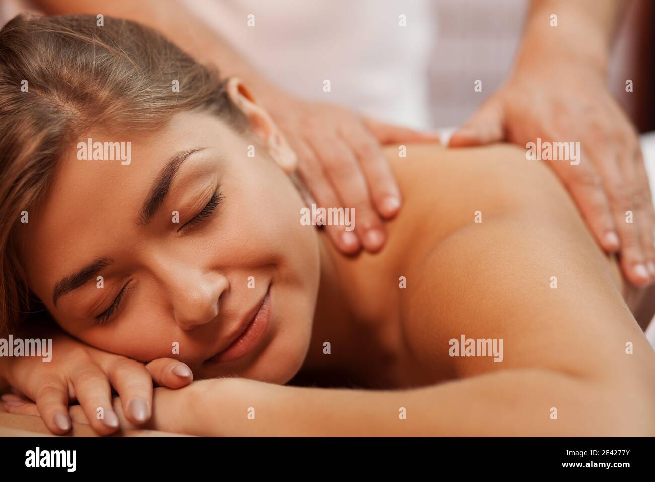 Beschnitten Nahaufnahme einer schönen glücklichen gesunden jungen Frau lächeln mit geschlossenen Augen, während professionelle Masseur massiert ihren Rücken und Schulter, Co Stockfoto