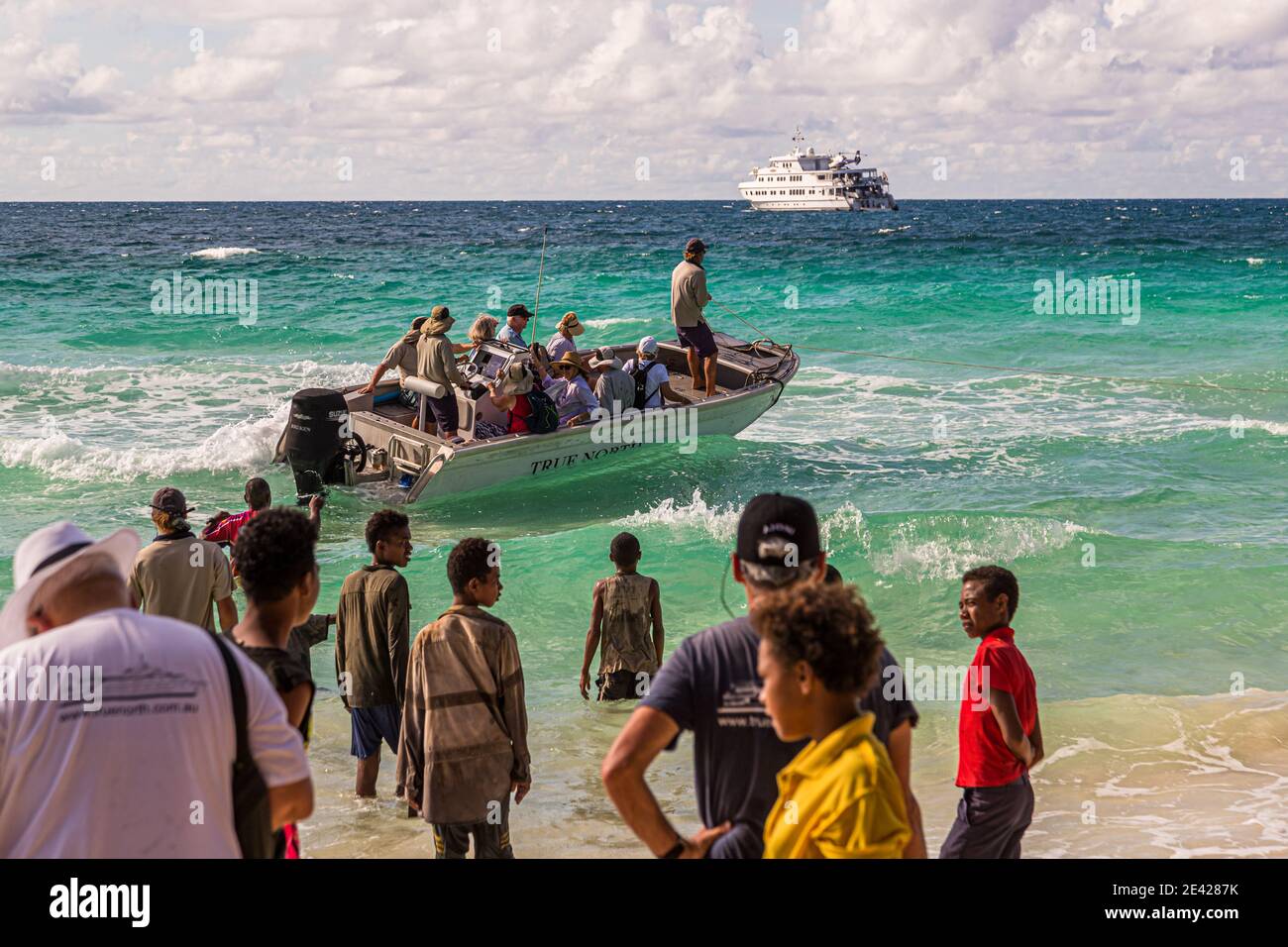 Lokale Leute und Touristen treffen sich an einem Strand in Papua-Neuguinea Stockfoto