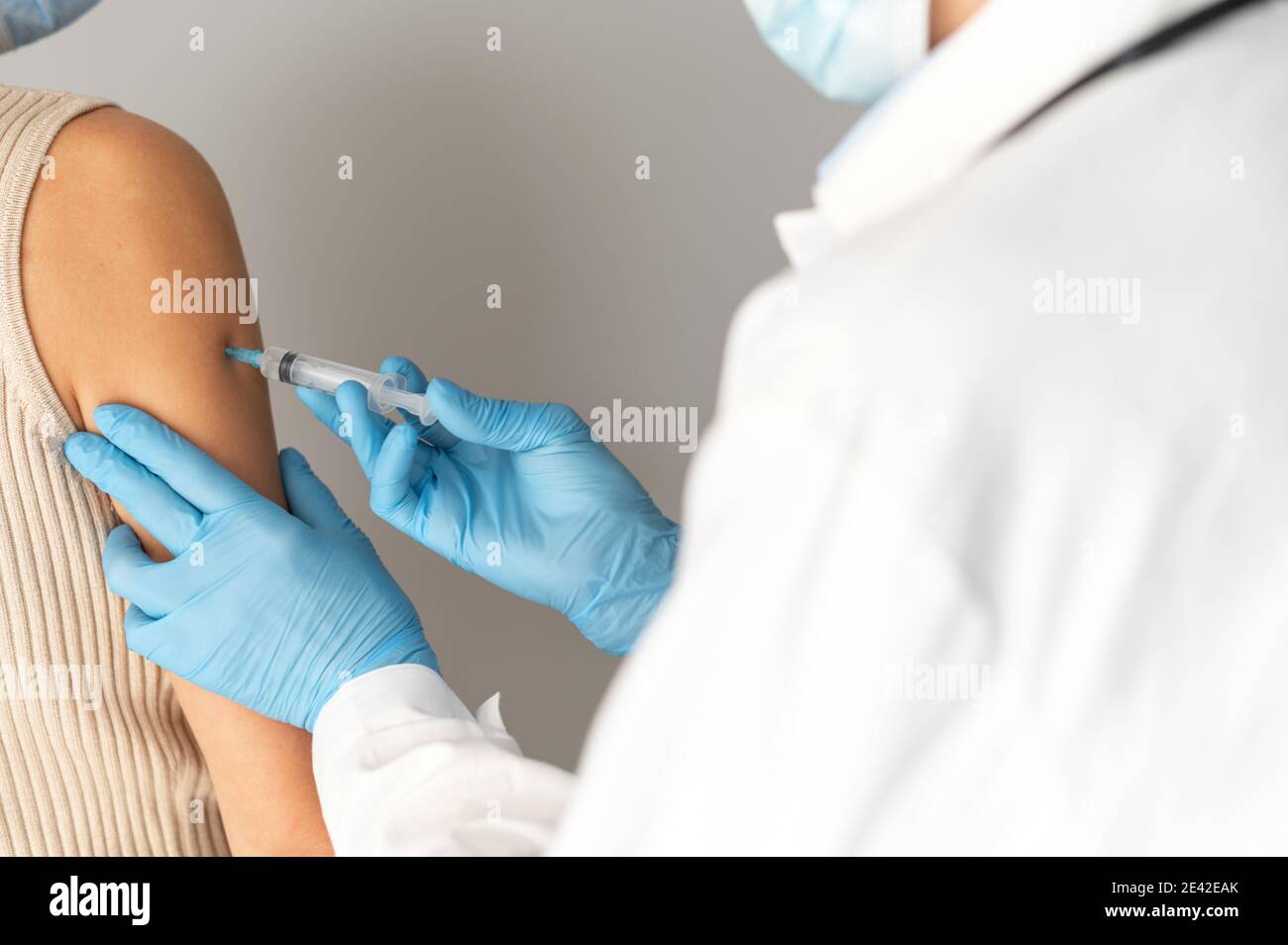 Nahaufnahme eines Arztes mit einer Spritze, die einen Impfstoff injiziert Stockfoto
