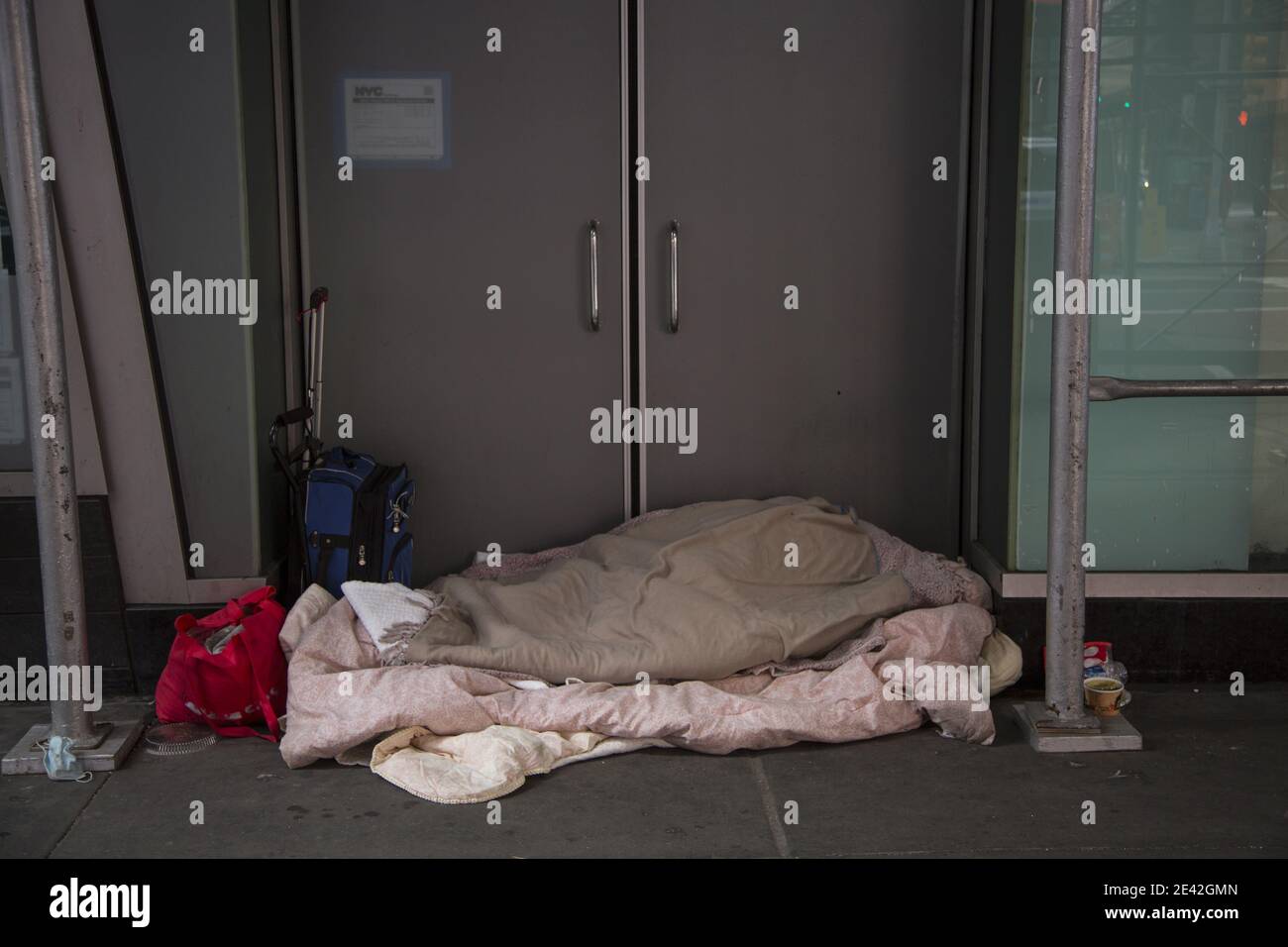 Obdachlose Person schlafen in einer Tür in Midtown Manhattan im Winter, New York City. Stockfoto
