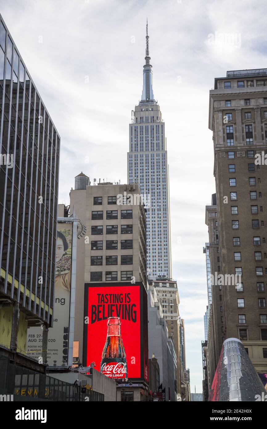 Zwei amerikanische Ikonen in Midtown Manhattan, eine Coca Cola Plakatwand mit dem Empire State Building im Hintergrund. Stockfoto