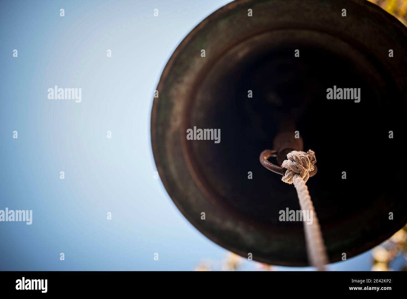 Glocke auf blauem Hintergrund. Klapper im Fokus Stockfoto