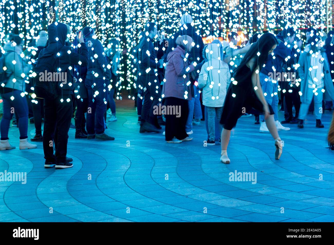 Balletttänzerin zeigt ihre Tanzbewegung im Winterlicht festival während der Weihnachtsferien in Canary Wharf London Vereinigtes Königreich Stockfoto