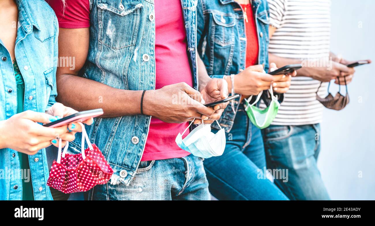 Nahaufnahme von Freunden Hände mit Gesichtsmasken mit Tracking App auf mobilen Smartphones - Junge Jahrtausende Menschen teilen Inhalte in sozialen Netzwerken Stockfoto
