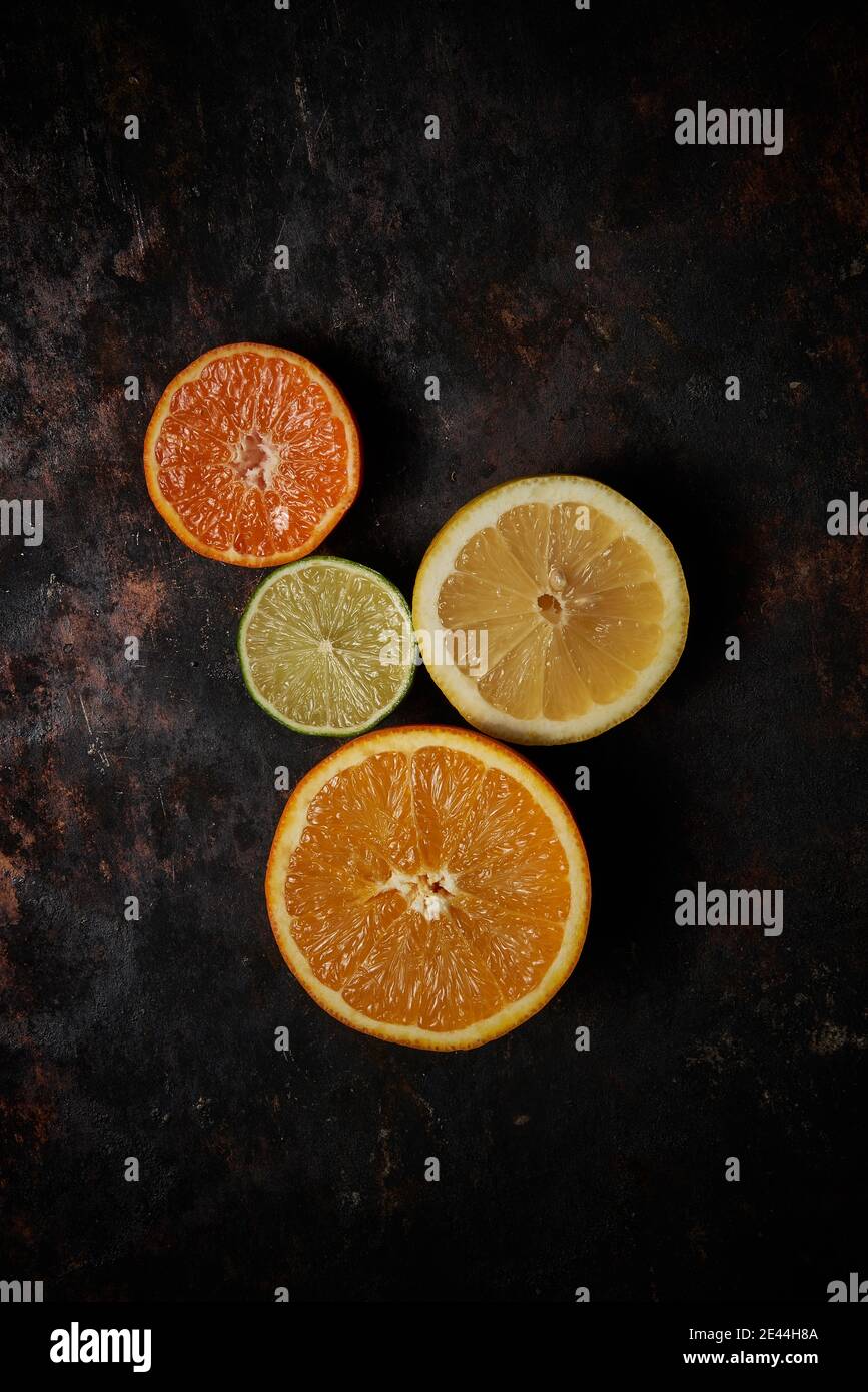 Draufsicht auf Orangen, Mandarinen und Zitrone auf dunklem rustikalem Holzhintergrund Stockfoto