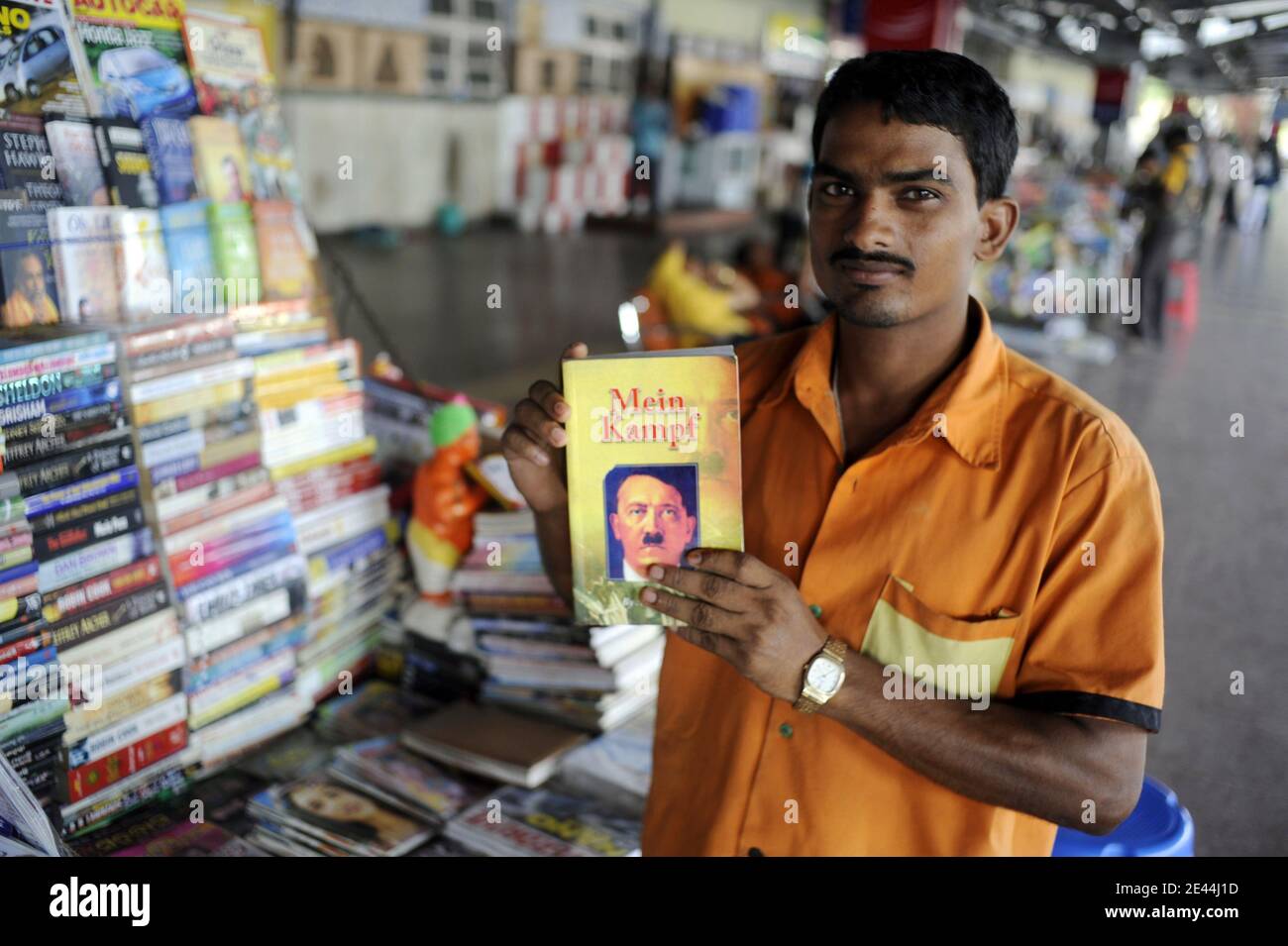 Ein Zeitungsverkäufer posiert mit einer Kopie von Adolf Hitlers "Mein Kampf", einem Bestseller in Indien, am 1. Mai 2009 im Bahnhof von Bhubaneswar, Orissa-Staat, Indien. Am 26. August 2008, ein paar hundert Hindu-Extremisten mit Äxten, Macheten und g bewaffnet Stockfoto