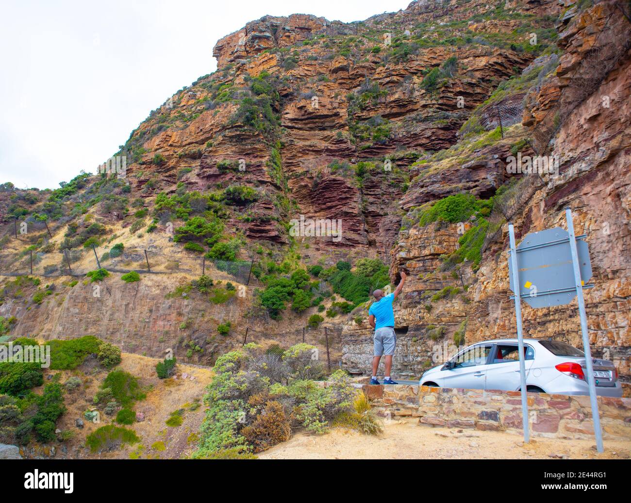 Chapman's Peak - Kapstadt, Südafrika - 19-01-2021 der Mann fotografiert den felsigen Berg auf der Seite des Chapmans Peak Drive. Stockfoto