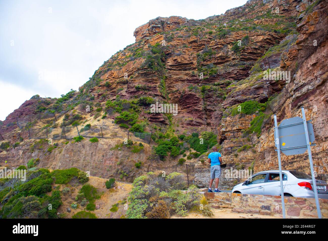 Chapman's Peak - Kapstadt, Südafrika - 19-01-2021 der Mann fotografiert den felsigen Berg auf der Seite des Chapmans Peak Drive. Stockfoto