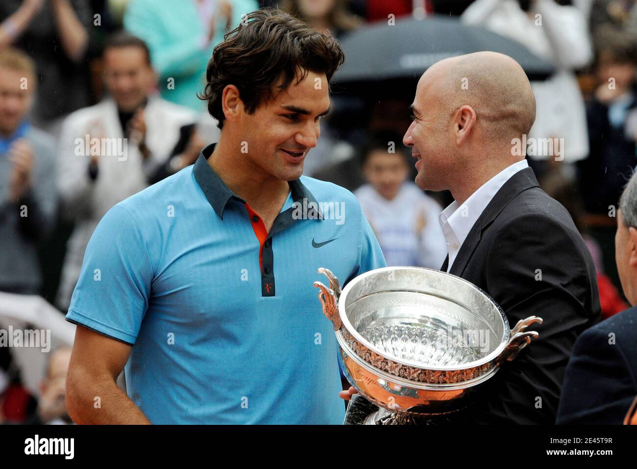 Der Schweizer Roger Federer erhält die Trophäe von dem ehemaligen  US-Tennisspieler Andre Agassi nach seinem Sieg im Einzel-Endspiel der  Herren beim French Open Tennisturnier im Roland Garros Stadion in Paris am  Sonntag,