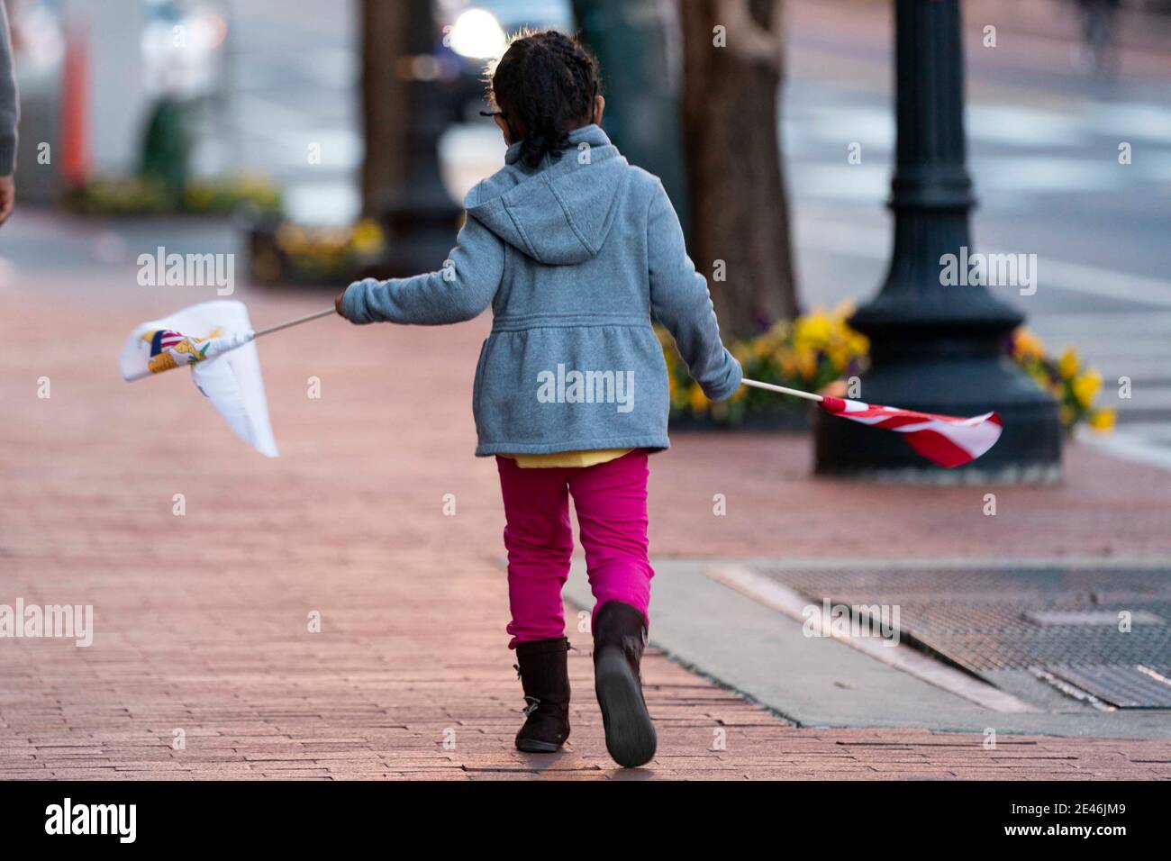 Washington, USA. Januar 2021. Ein Mädchen, das Flaggen trägt, die am 21. Januar 2021 vom "Flaggenfeld" für den Einweilungstag genommen wurden, geht eine Straße in der Innenstadt von Washington, DC entlang. (Foto von Dominick Sokotoff/Sipa USA) Quelle: SIPA USA/Alamy Live News Stockfoto