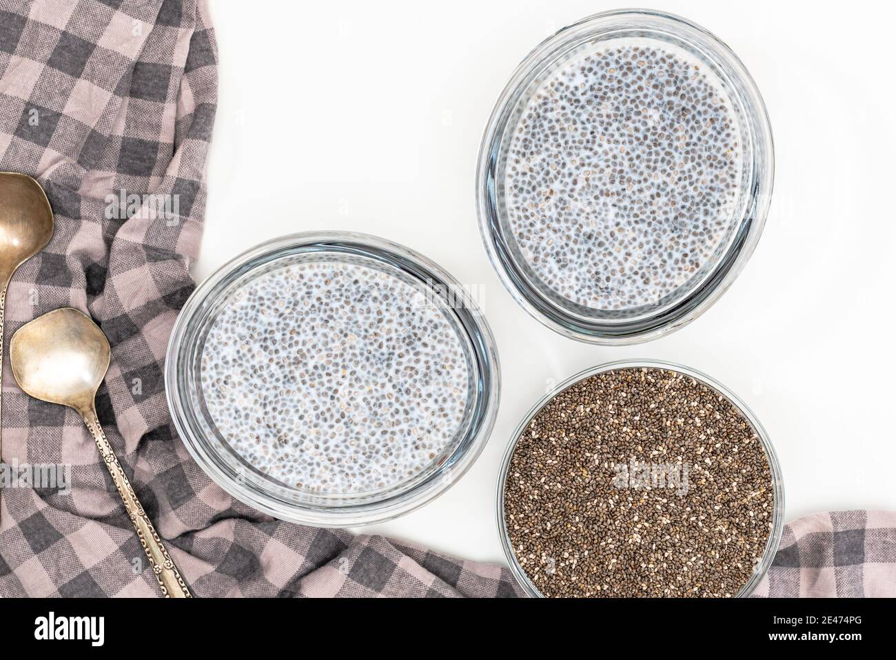 Chia Samen in einer Glasschüssel und Chia Samenpudding auf weißem Hintergrund, flach legen Stockfoto