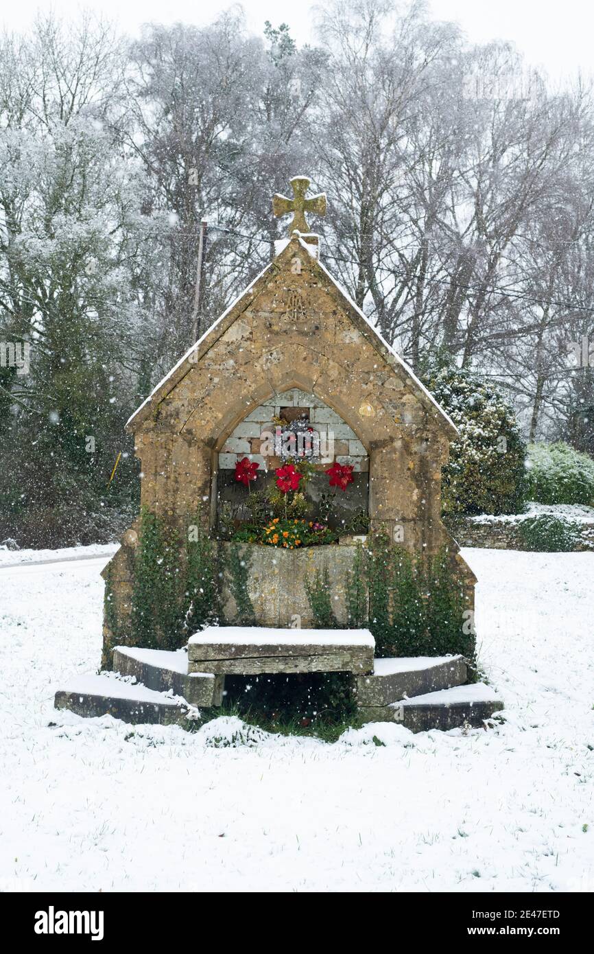 Viktorianischer Trinkbrunnen im Dezember Schnee. Wyck Rissington, Cotswolds, Gloucestershire, England Stockfoto