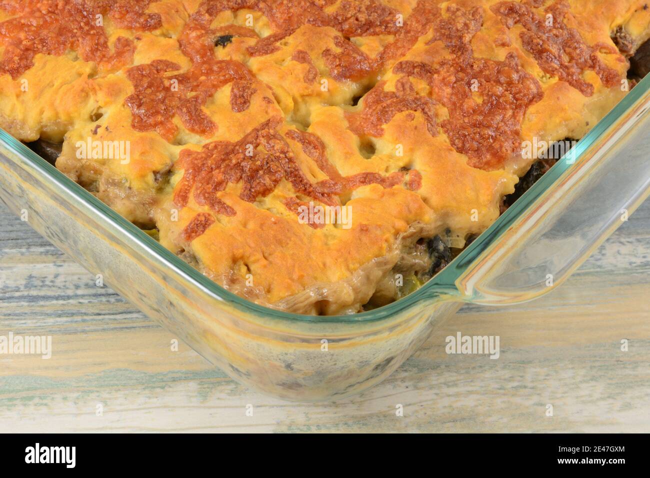 Gebackenes Rindfleisch und Gemüseauflauf mit Cheddar-Käse-Kekskruste In Glasbackform Stockfoto