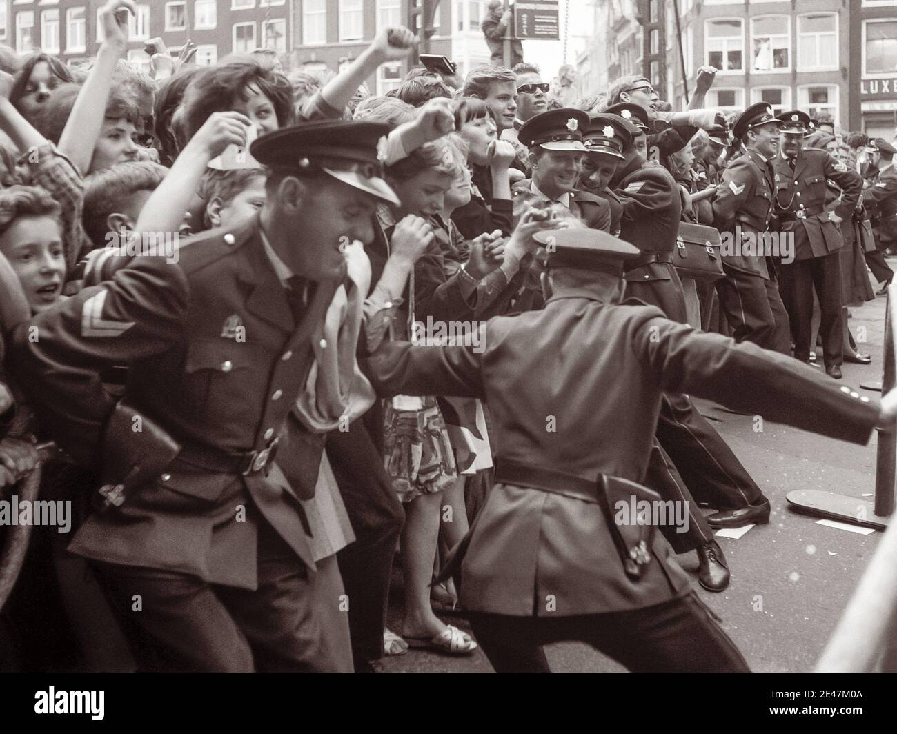 Die Polizei kämpft, um die Massen von Beatles-Fans zurückzuhalten, als die englische Rockband am 5. Juni 1964 nach Amsterdam, Nordholland kam. Stockfoto