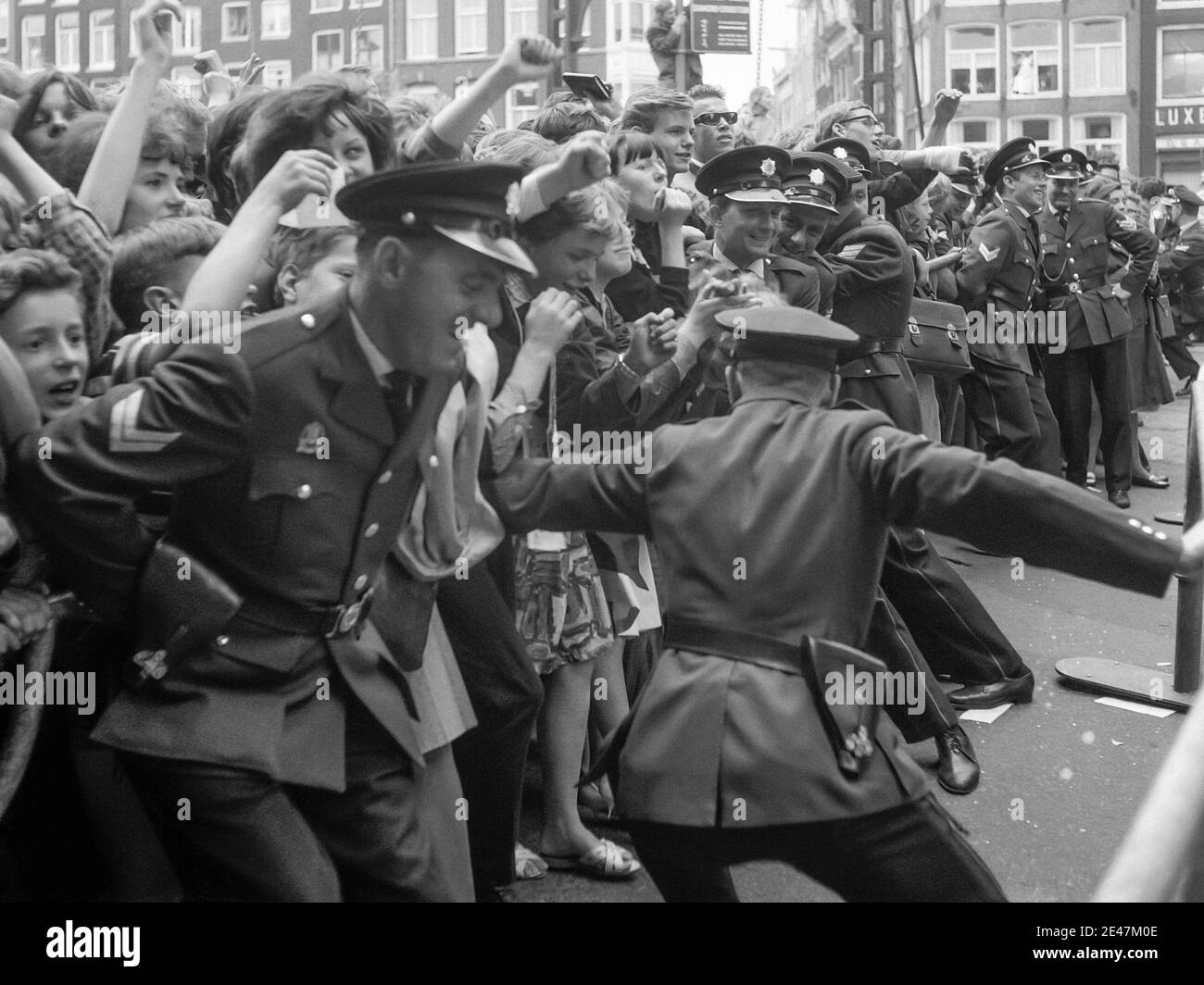 Die Polizei kämpft, um die Massen von Beatles-Fans zurückzuhalten, als die englische Rockband am 5. Juni 1964 nach Amsterdam, Nordholland kam. Stockfoto