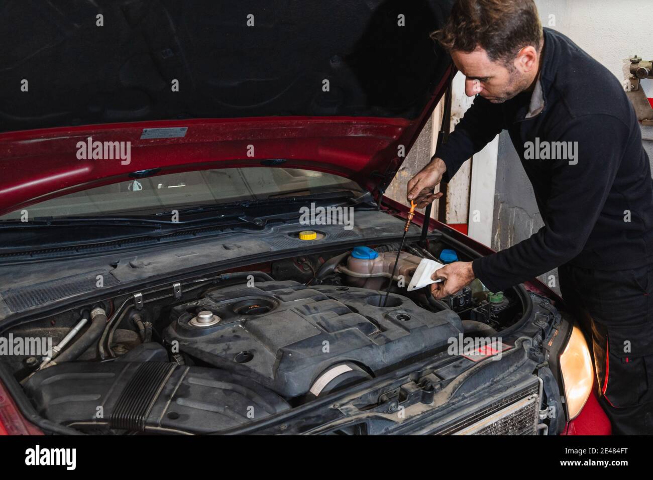 Mechaniker, der den Ölstand im Motor des Autos betrachtet. Konzept der Automechanik Stockfoto