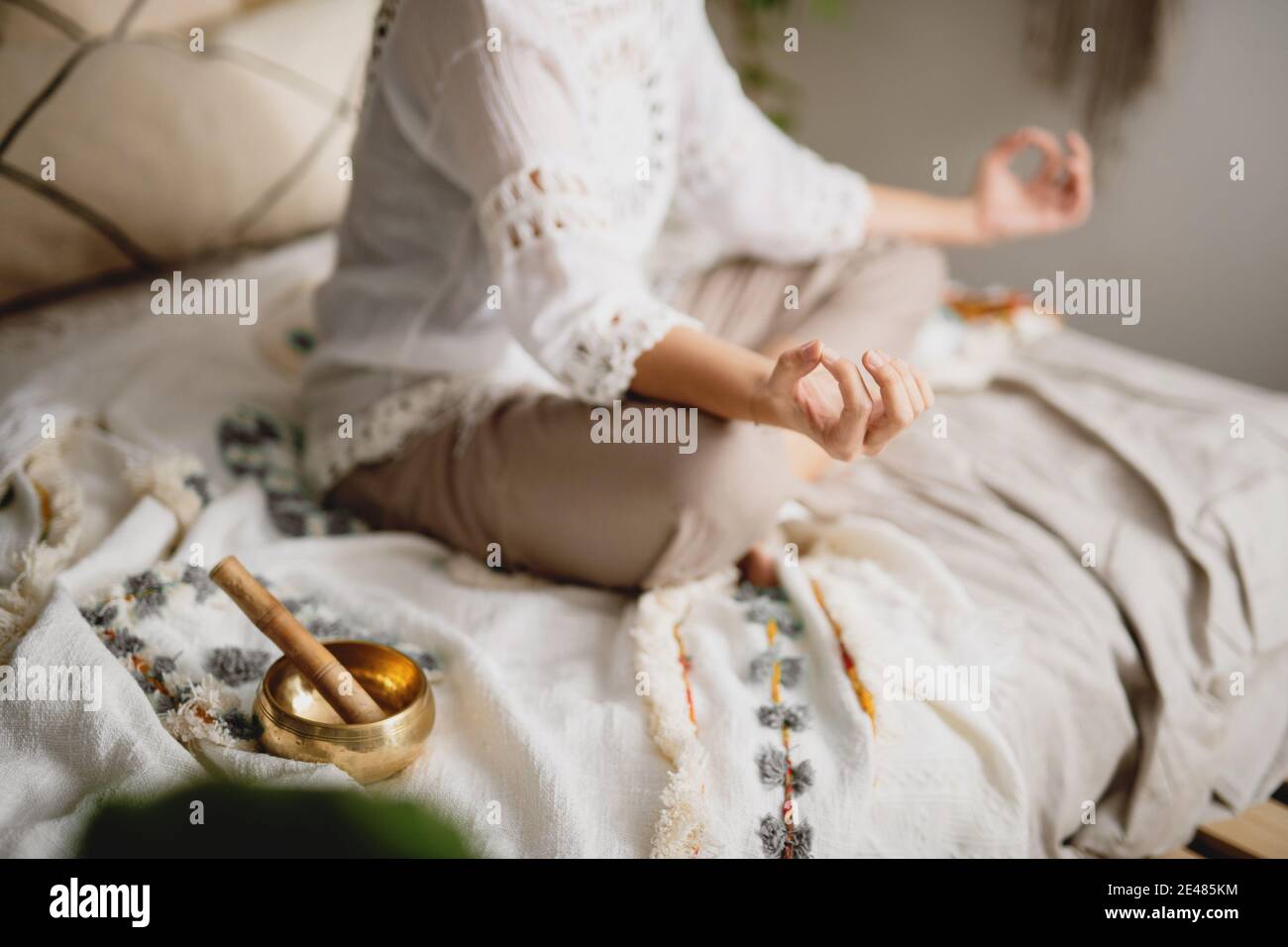 Beschnittene Ansicht einer Frau, die in ihrem Schlafzimmer meditiert. Yoga, Meditation, Relax-Konzept. Stockfoto