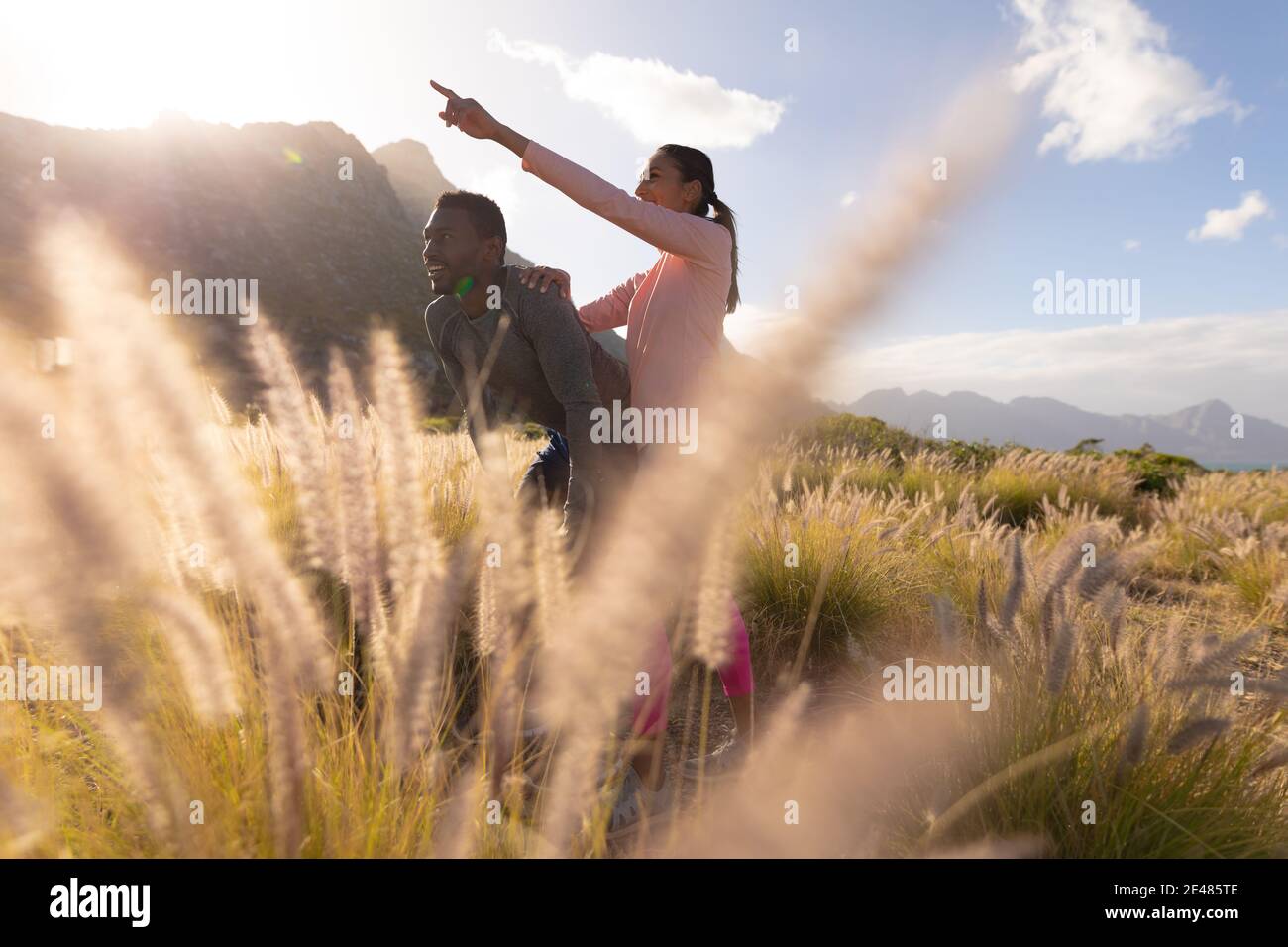 Fit afroamerikanischen Paar in Sportswear auf den Knien lehnen Im hohen Gras Stockfoto