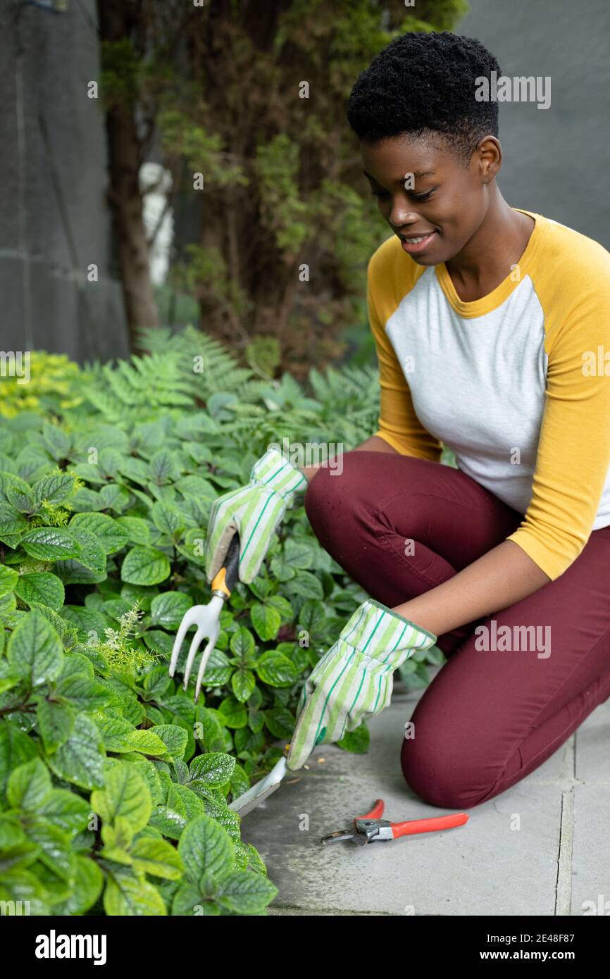 afroamerikanische Frau trägt Gartenhandschuhe Garten im Garten Stockfoto