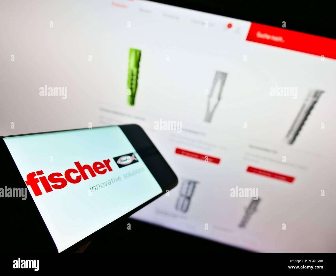 Handy mit Logo der Fischer Group (Fischerwerke) vor der Produktwebsite mit Dübel. Konzentrieren Sie sich auf den linken Teil des Telefonbildschirms. Stockfoto
