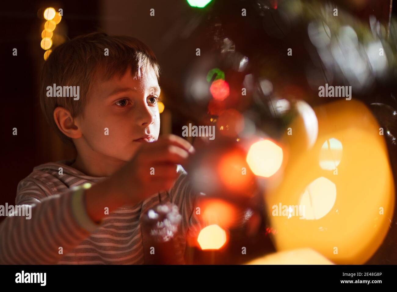 Porträt von 8 Jahre alten Jungen Dekoration Weihnachtsbaum Stockfoto