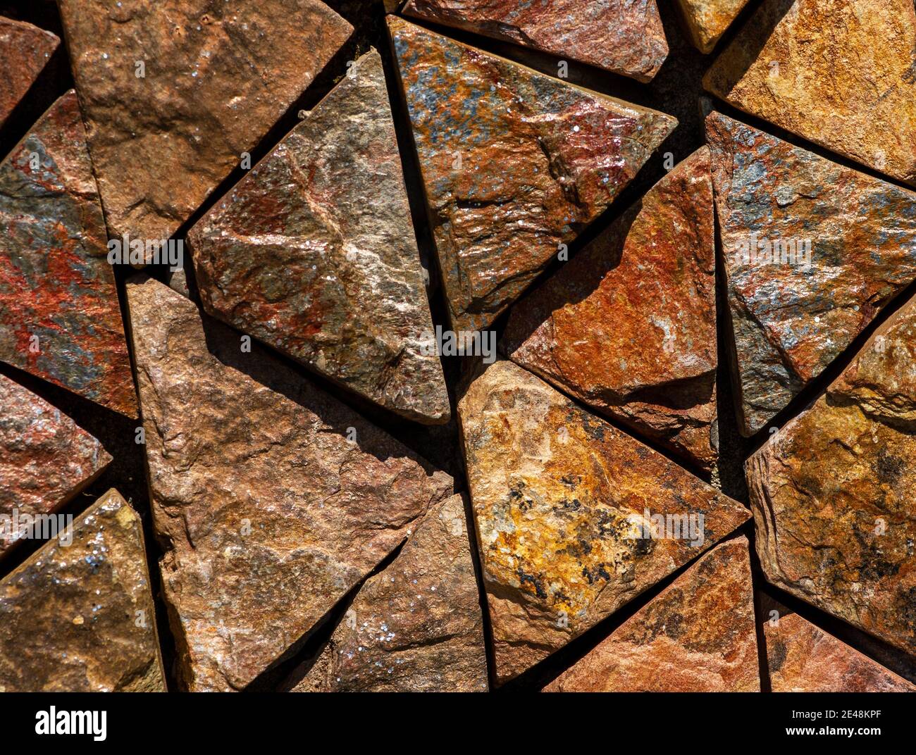 Braun-rote monochrome Oberfläche der Granitwand Nahaufnahme. Natürliche dekorative Stein Hintergrund Stockfoto