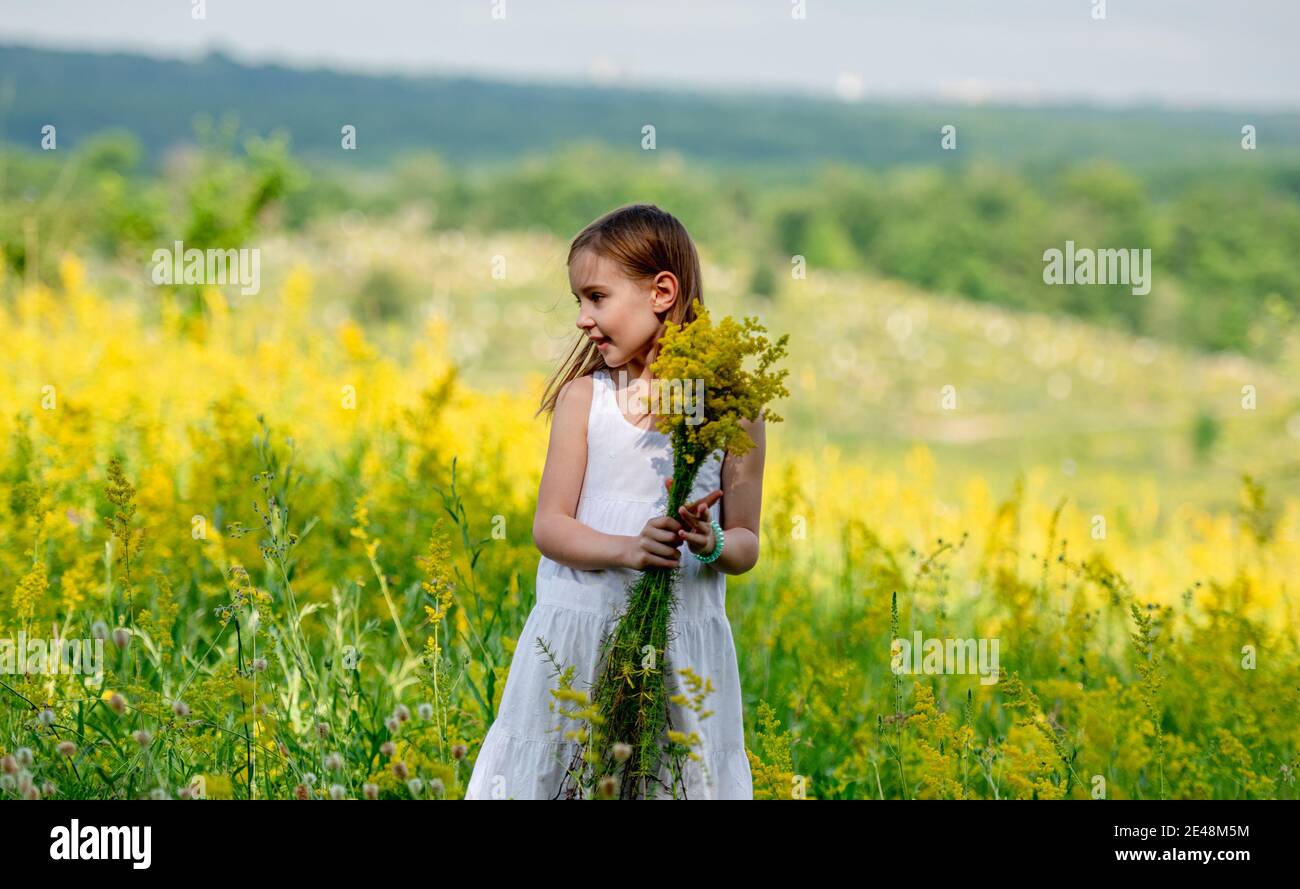 Nettes kleines Mädchen hält Wildblumen Bouquet Stockfoto