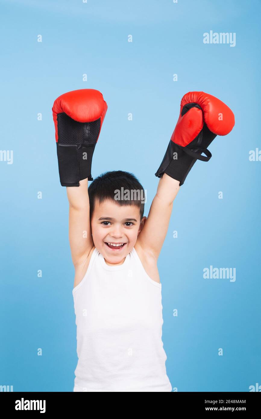 Ein Kinderboxer hebt als Sieger die Fäuste hoch. Konzept des Sieges Stockfoto