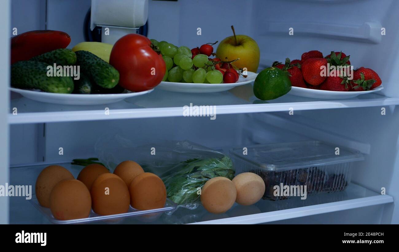 Bild mit einem offenen Kühlschrank voll mit frischem Obst und Gemüse Stockfoto