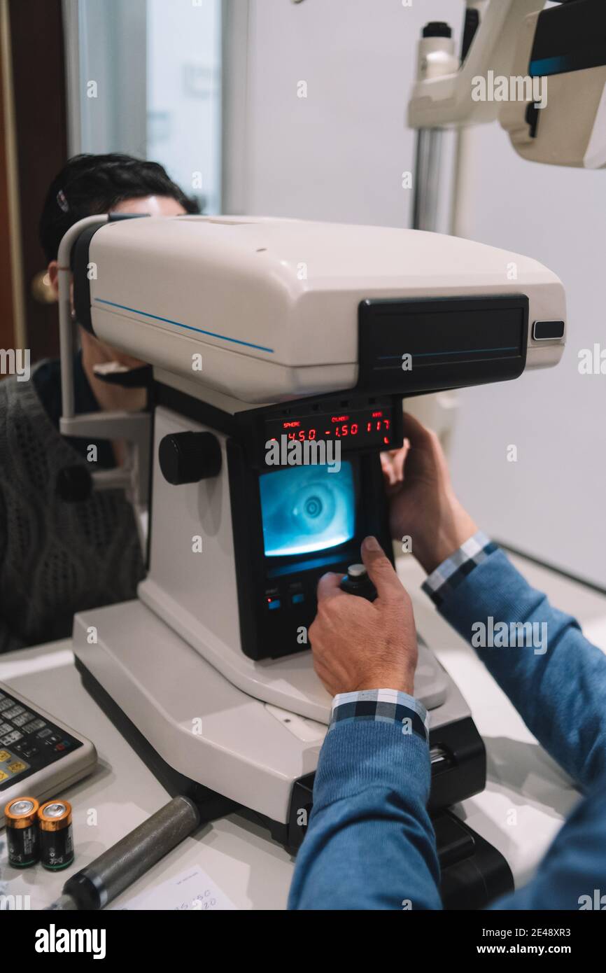 Optik-Spezialist sieht Augenlicht auf ein Mädchen Patienten in einem Augenklinik Stockfoto