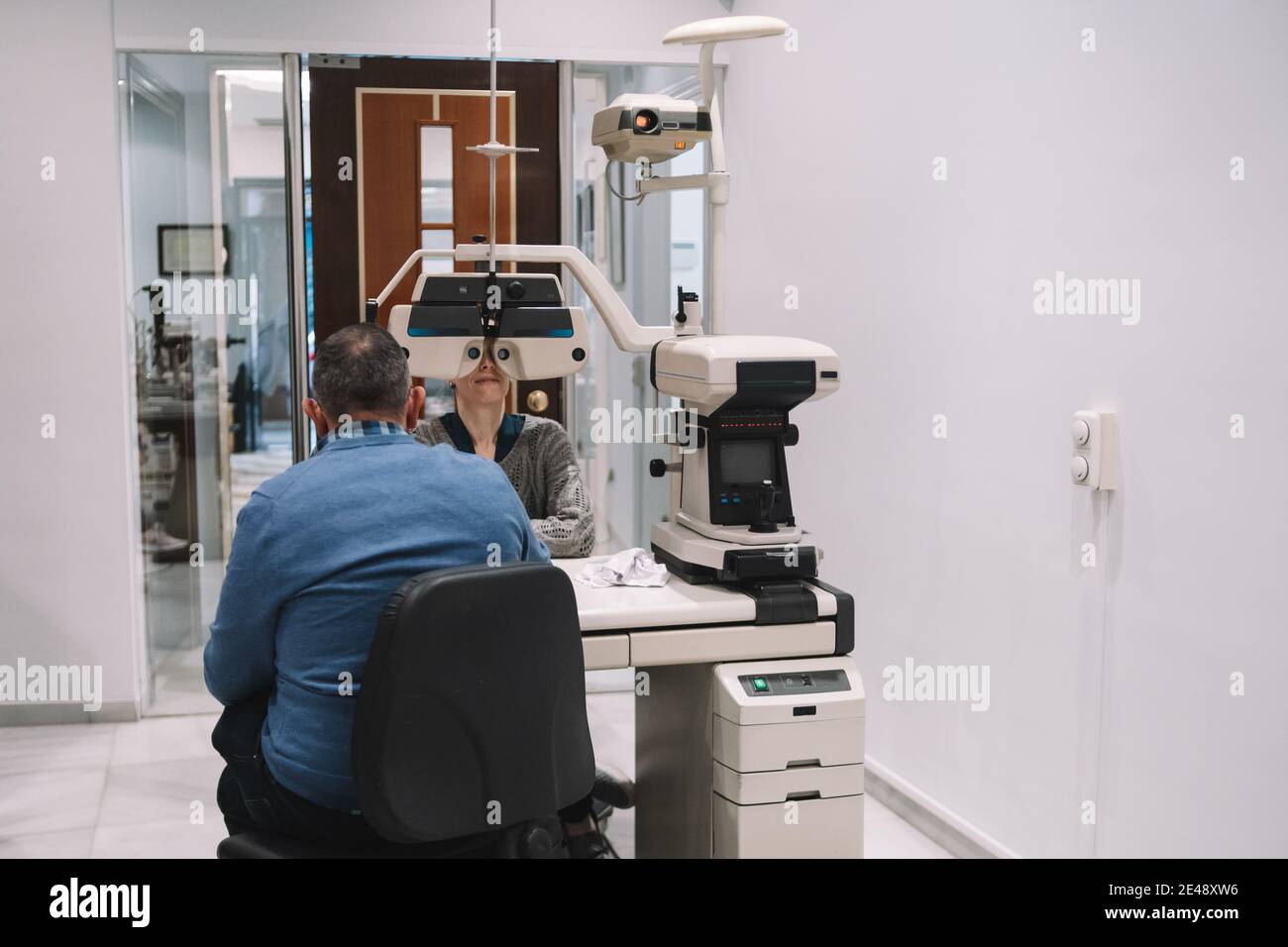 Optikspezialist betrachtet Augenlicht zu einer Frau Patienten in einem Augenklinik Stockfoto
