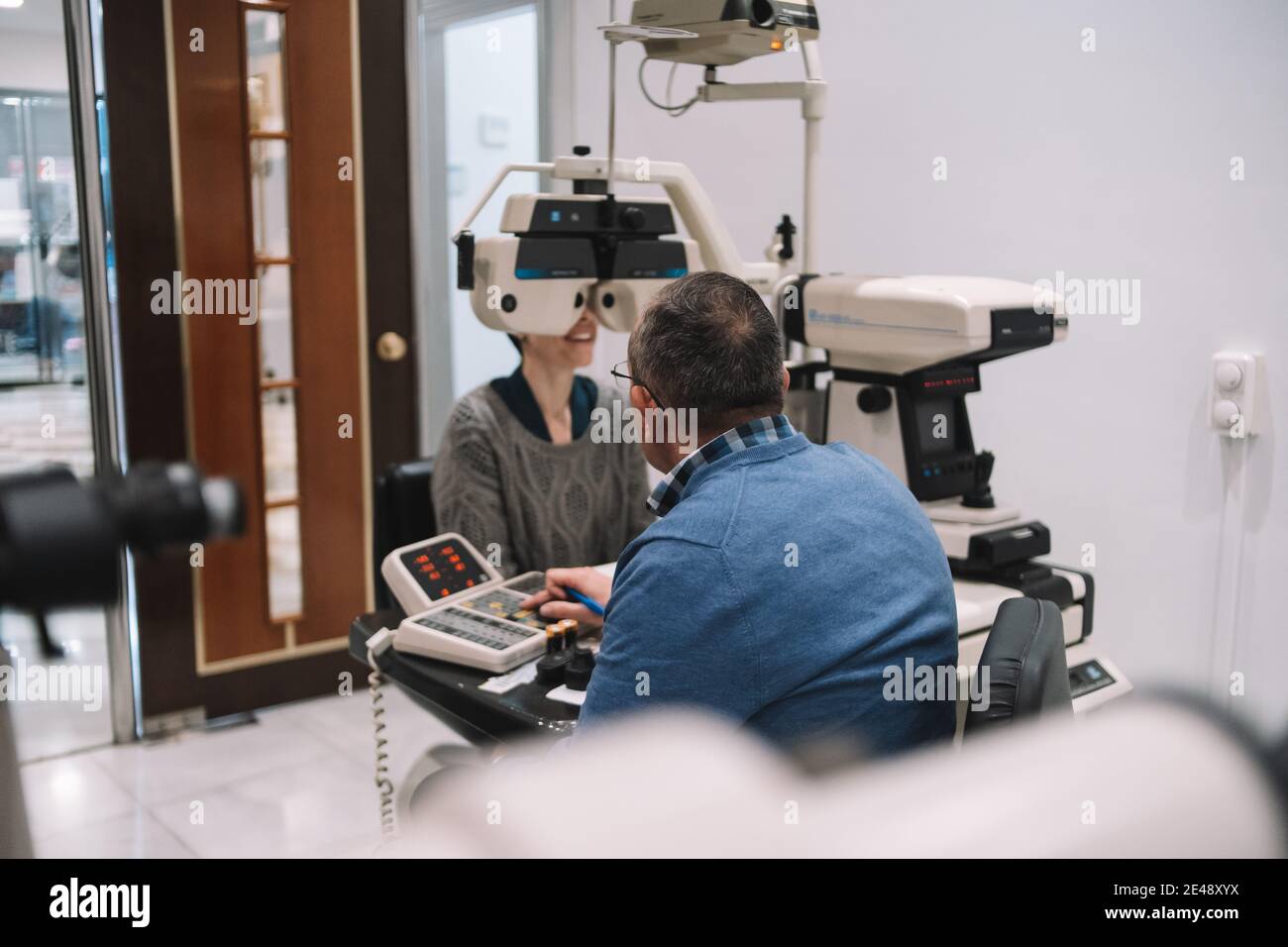 Optik-Spezialist sieht Augenlicht auf ein Mädchen Patienten in einem Augenklinik Stockfoto