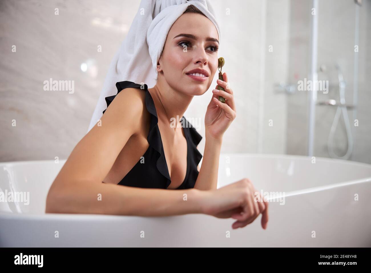 Hübsche Frau mit einer Gesichtsmassage zu Hause Stockfoto