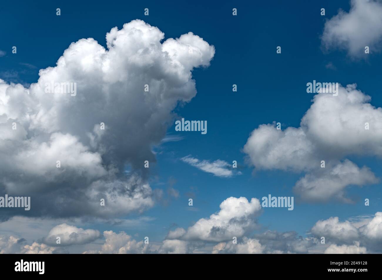 Blauer Himmelshintergrund mit flauschigen Wolken Stockfoto