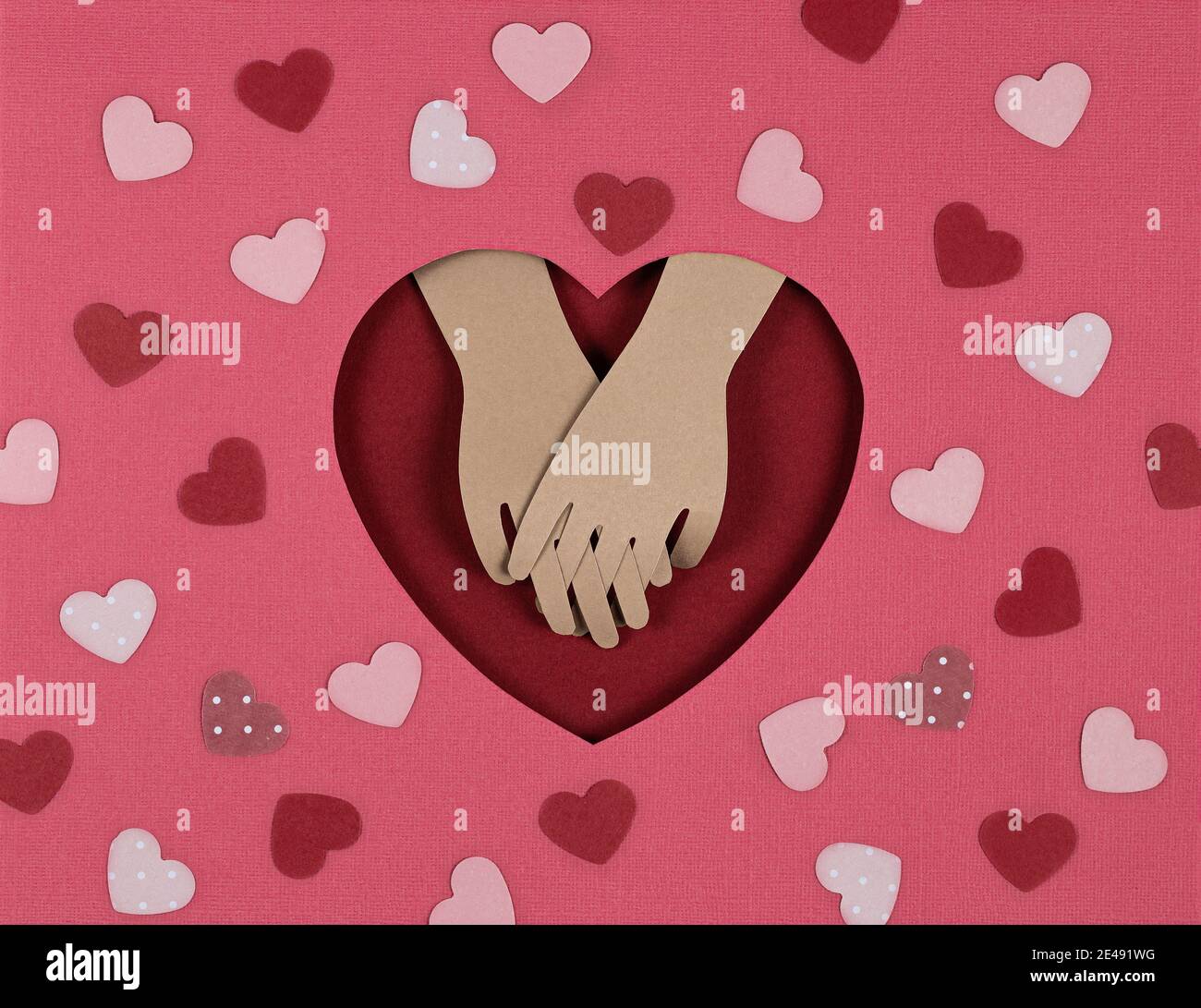 Valentinskarte. Kreative Papier geschnitten Hintergrund mit Origami-Herz und Look der Liebhaber Hände. Hände am roten Herzen halten. Papierkunst über valentin Stockfoto