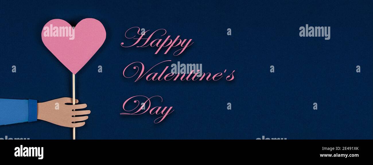 Hand hält ein Papier Origami Herz mit Inschrift Happy Valentines Day. Flatlay, Draufsicht, Kopierbereich. Valentinstag Papier Art. Feiertag, Geburtstag, V Stockfoto