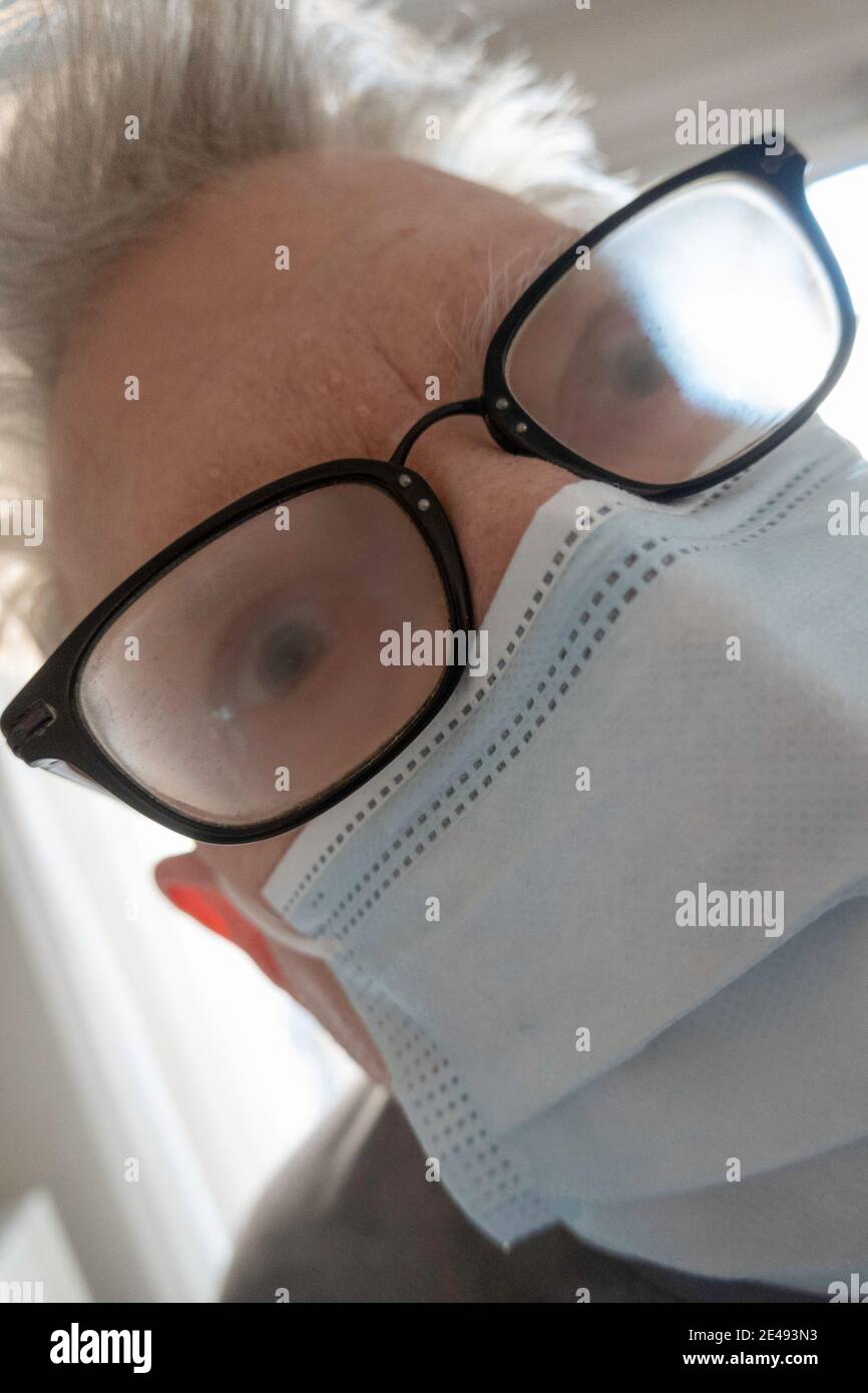 Älterer Mann mit Gesundheits- und Sicherheitsbedenken trägt eine schützende Gesichtsmaske mit beschlagener Brille New York City, USA Stockfoto