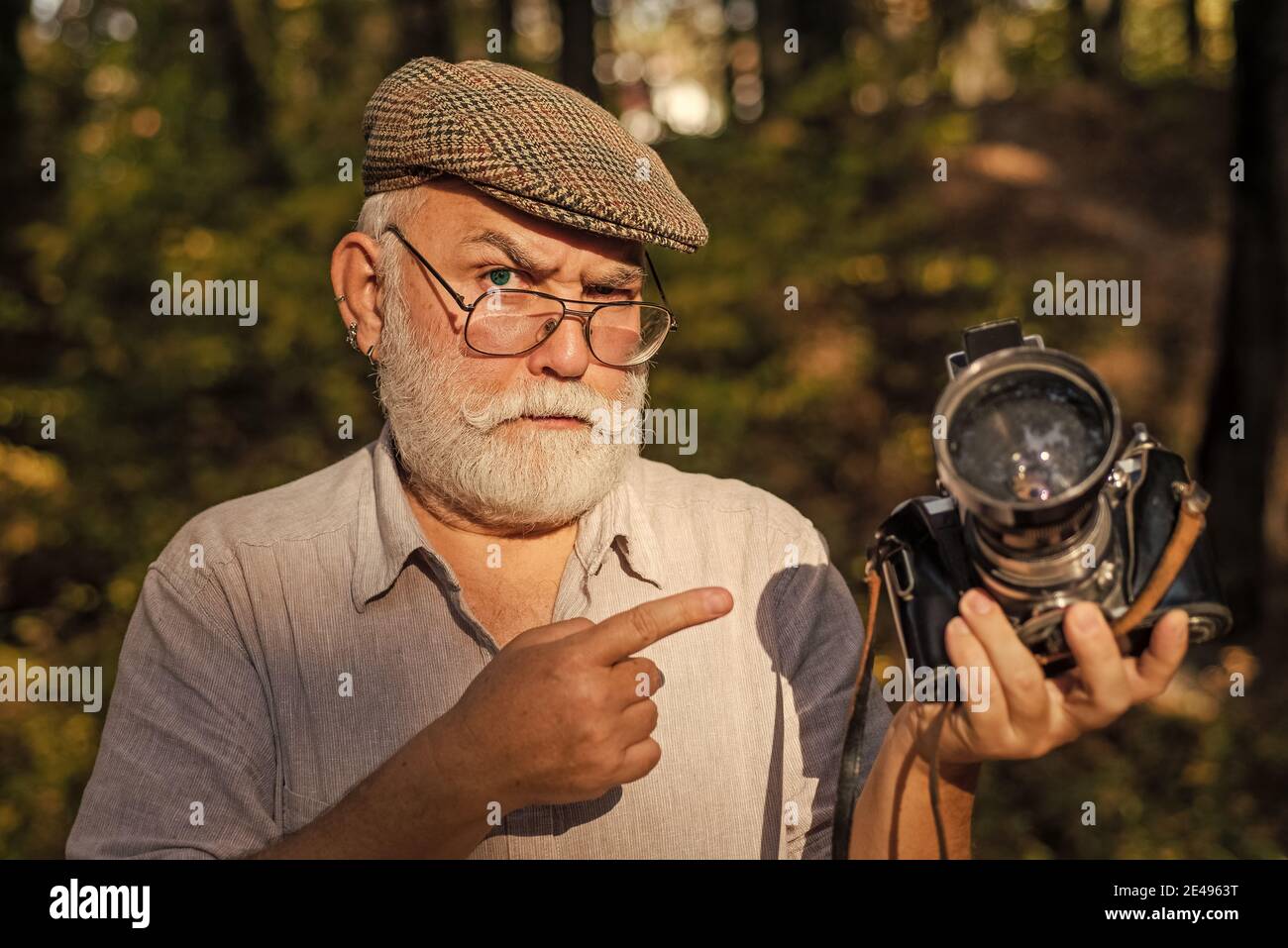 Stop oder Il Shoot. Alte Kamera Mann Punkt Finger Sommer im Freien. Fotoshooting. Reiseaufnahmen. Urlaubsfotograf einstellen. Halten Sie Erinnerungen von der Reise fest. Stockfoto