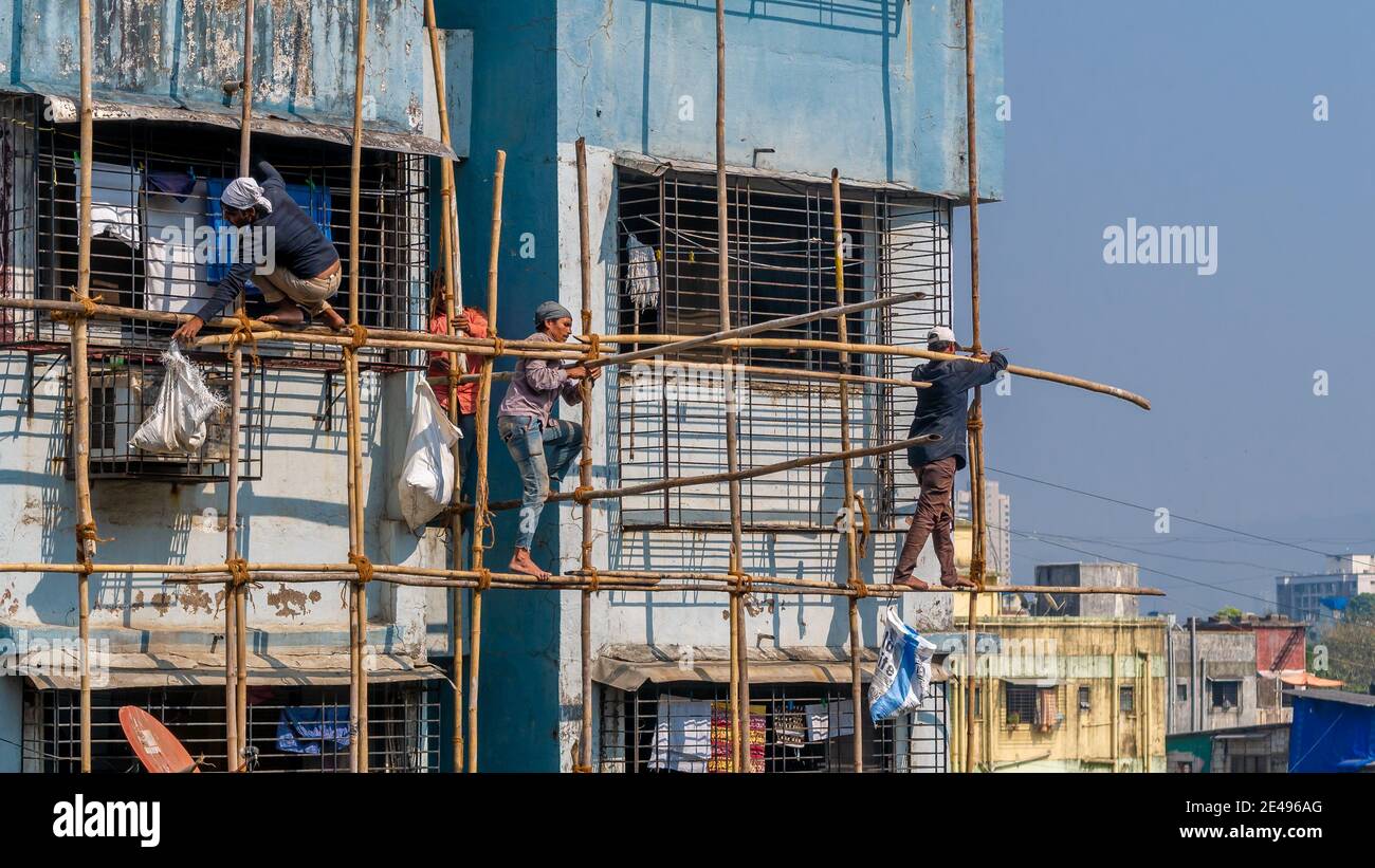 MUMBAI, INDIEN - 17. Dezember 2020 : Bauarbeiter bauen eine Bambusstruktur auf einer Gebäudewand, um die Instandhaltung des Gebäudes zu initiieren. Keine Prote Stockfoto